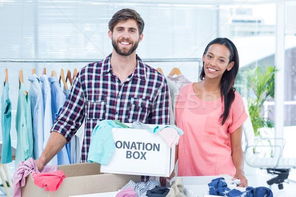Smiling young friends volunteers separating clothes Stock photo © wavebreak_media