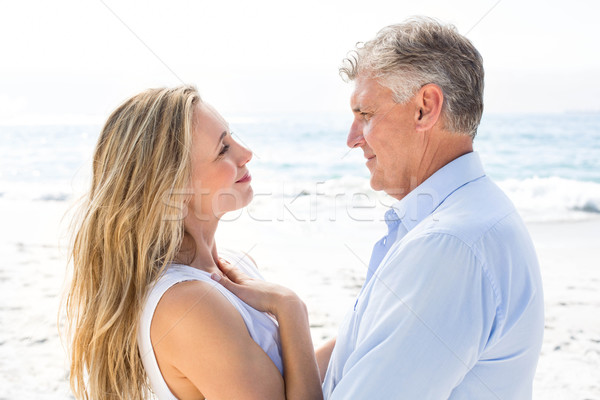 Happy couple standing by the sea and smiling at each other Stock photo © wavebreak_media