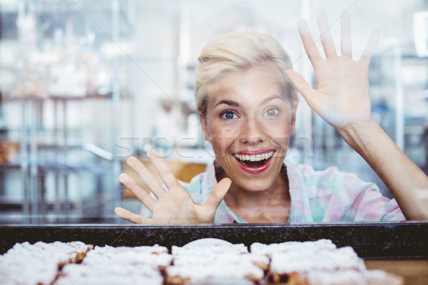 Stock photo: Astonished pretty woman looking at cup cakes 