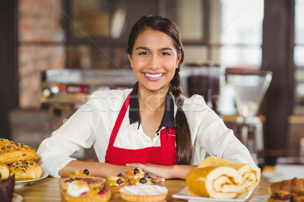 Smiling waitress standing over pastries Stock photo © wavebreak_media