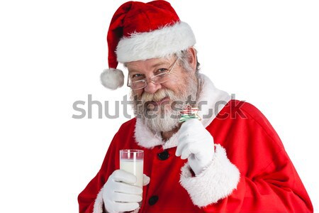Santa claus holding glass of milk and christmas cookies Stock photo © wavebreak_media