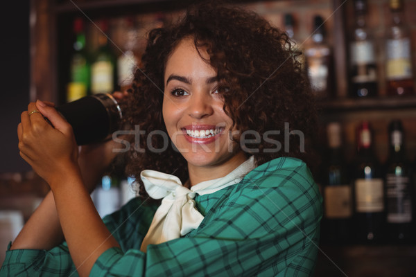 Female bartender mixing a cocktail drink in cocktail shaker Stock photo © wavebreak_media