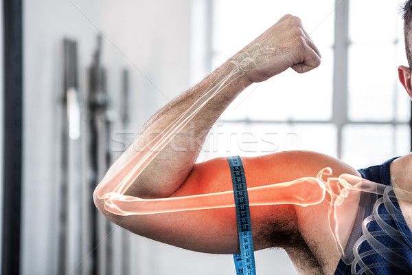 Stock photo: Highlighted arm of man measuring biceps with measuring tape