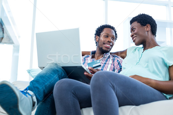 Para uśmiechnięty posiedzenia sofa człowiek laptop Zdjęcia stock © wavebreak_media