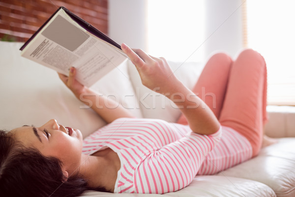 Stock photo: Smiling asian woman on couch reading