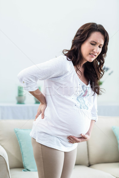 Foto stock: Mulher · grávida · doloroso · de · volta · sala · de · estar · mulher · casa