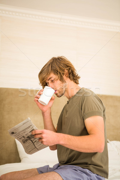 Handsome man reading the news and drinking coffee Stock photo © wavebreak_media