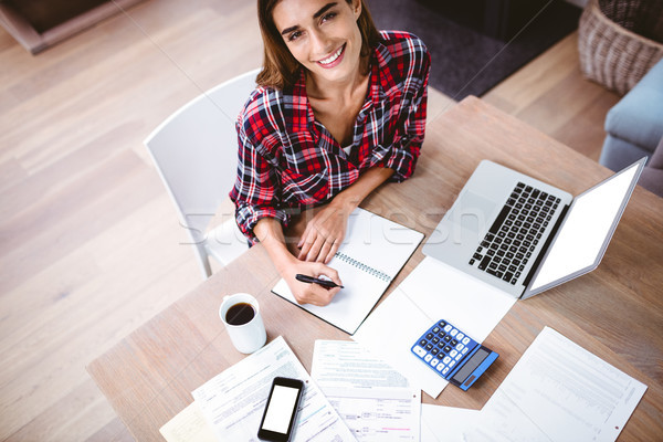 High angle portrait of smiling woman writing in notepad Stock photo © wavebreak_media