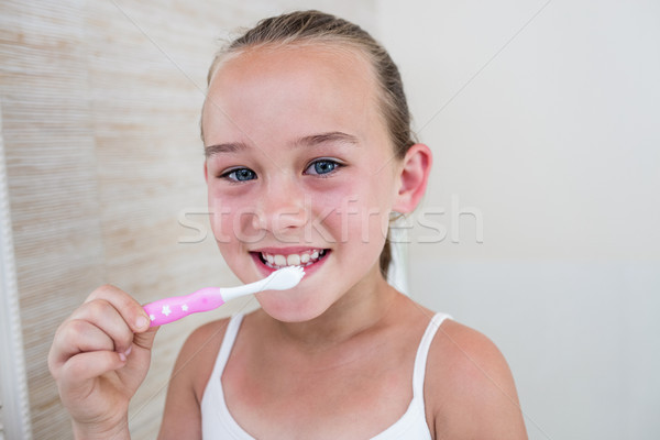 Happy girl brushing her teeth in bathroom Stock photo © wavebreak_media