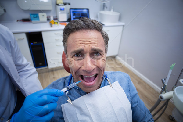 Dentist injecting anesthetics in scared male patient mouth Stock photo © wavebreak_media