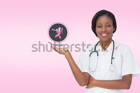 Smiling nurse shows a copy space with open hand on a pink background Stock photo © wavebreak_media