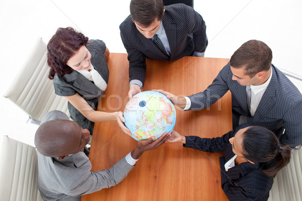 Stock photo: High Angle of business people holding a globe. Global business