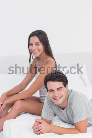 Smiling love couple sitting on bed with laptop Stock photo © wavebreak_media