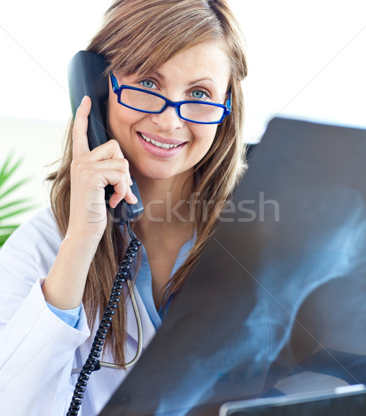 Beautiful female doctor with glasses sitting in office and phoneing Stock photo © wavebreak_media