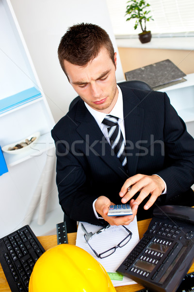 Concentrated businessman using his calculator in the office Stock photo © wavebreak_media