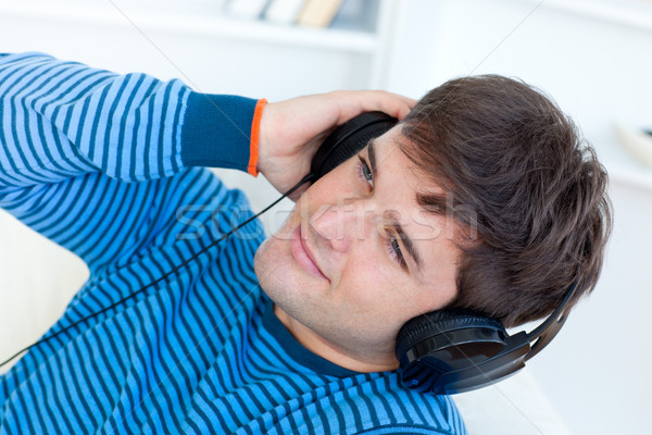 Szczęśliwy młody człowiek słuchawki relaks muzyki sofa Zdjęcia stock © wavebreak_media