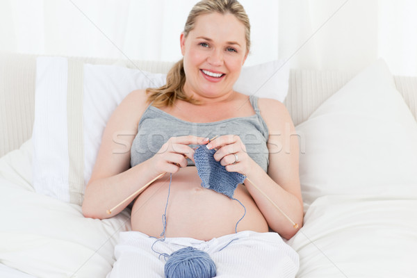 Adorable pregnant woman knitting on her bed Stock photo © wavebreak_media