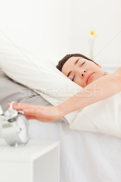 Portrait of a brunette turning off her alarm clock in her bedroom Stock photo © wavebreak_media