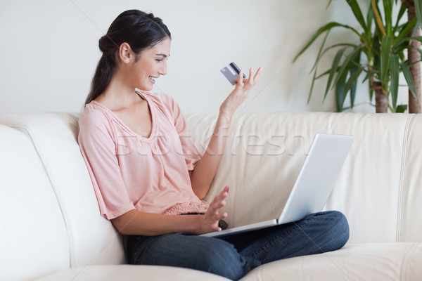 Stock photo: Happy woman shopping online in her living room