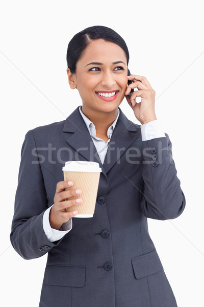 Close up of saleswoman with paper cup on her cellphone against a white background Stock photo © wavebreak_media