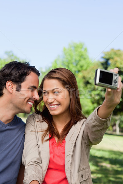 Young woman and her friend look at each other while she takes a photo of them together using her cam Stock photo © wavebreak_media
