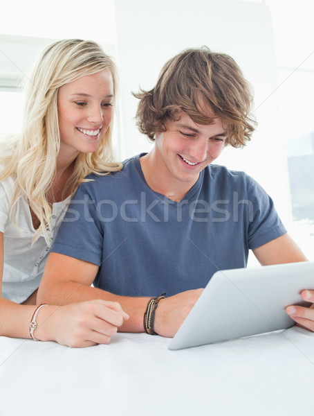 Souriant couple s'asseoir ensemble comprimé maison [[stock_photo]] © wavebreak_media