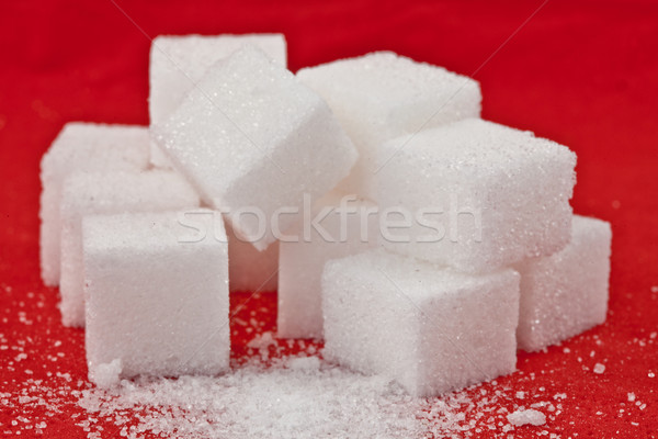 Stock photo: Stack of sugar  against a red background