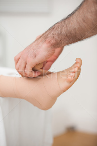 Doctor bandaging an ankle in a medical room Stock photo © wavebreak_media