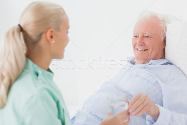 Home nurse giving man glass of water Stock photo © wavebreak_media