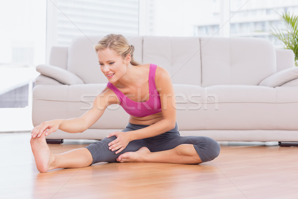 Fit blonde sitting on floor stretching her leg Stock photo © wavebreak_media