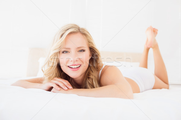 Csinos fiatal szőke nő mosolyog kamera ágy Stock fotó © wavebreak_media