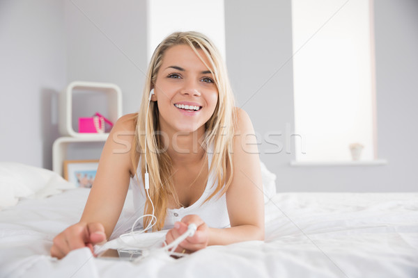 Beautiful woman listening music in bed at home Stock photo © wavebreak_media