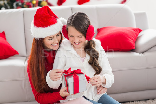 Festive mother and daughter with a christmas gift Stock photo © wavebreak_media