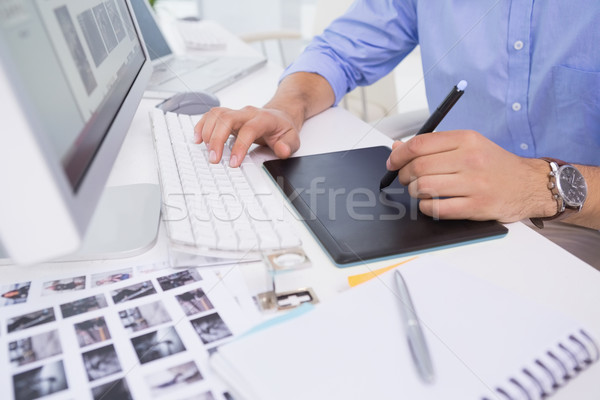 Stock photo: Graphic designer using digitizer at his desk