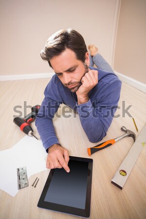 Casual man lying on floor using tablet pc for DIY instructions Stock photo © wavebreak_media