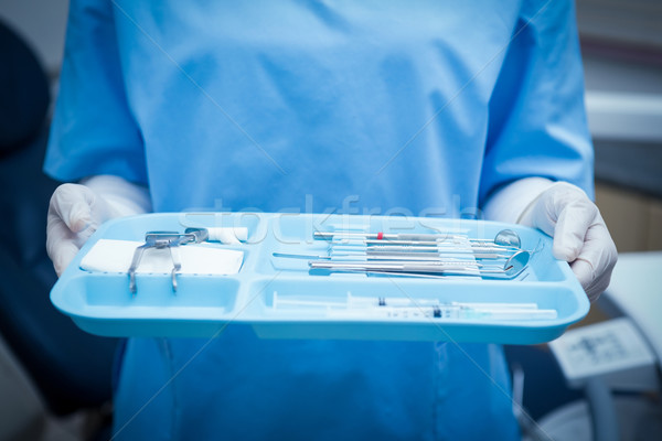 Mid section of dentist in blue scrubs holding tray of tools Stock photo © wavebreak_media