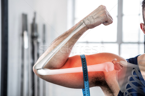 Highlighted arm of man measuring biceps with measuring tape Stock photo © wavebreak_media