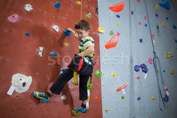 Stock photo: Boy practicing rock climbing in fitness studio