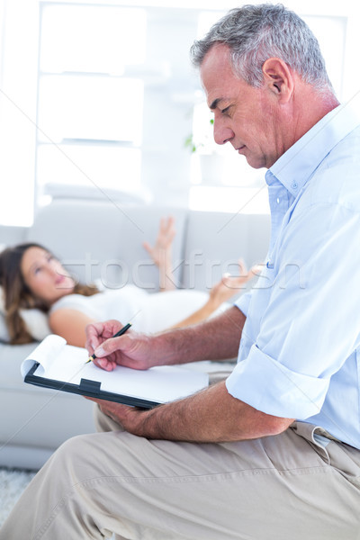 Therapist writing on notepad with female patient  Stock photo © wavebreak_media
