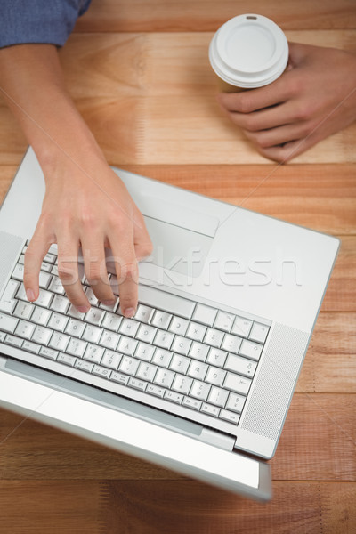 Man holding disposable cup while working on laptop Stock photo © wavebreak_media