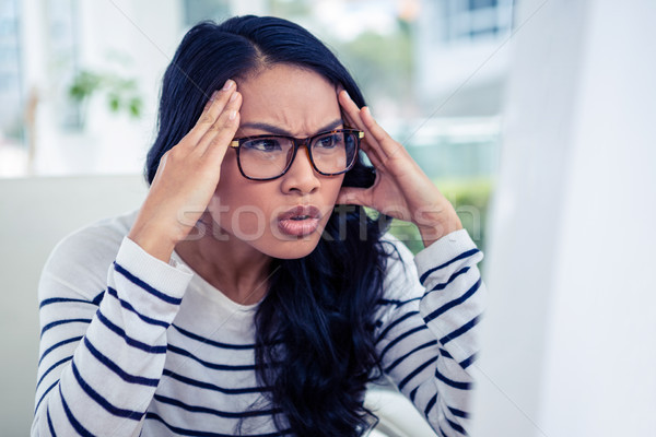 Frowning Asian woman looking at laptop with hands on head Stock photo © wavebreak_media
