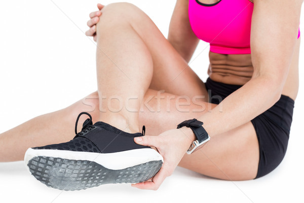 Injured female athlete sitting and removing her shoe Stock photo © wavebreak_media
