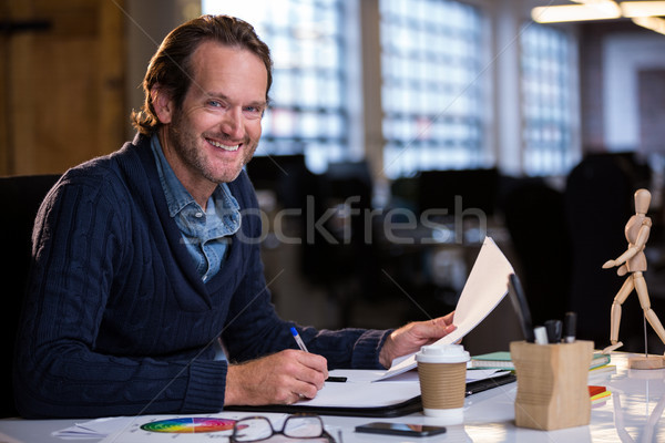 Businessman smiling while working at desk Stock photo © wavebreak_media