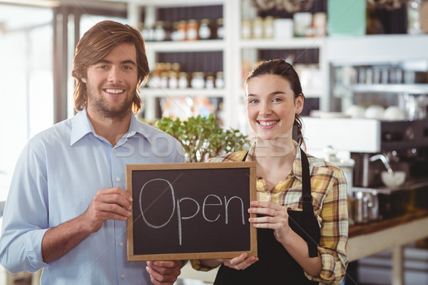 Portrait of man and waitress holding chalkboard with open sign Stock photo © wavebreak_media