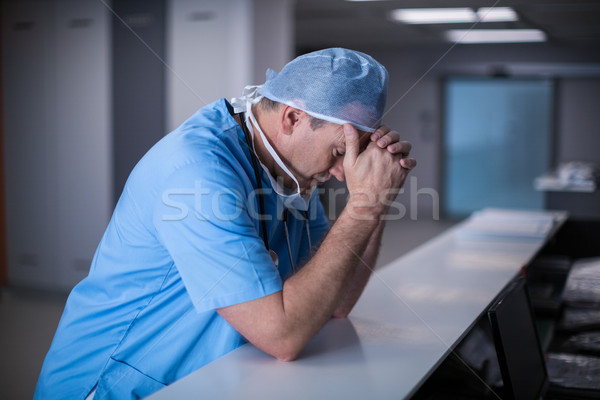 Depressed surgeon leaning on desk Stock photo © wavebreak_media