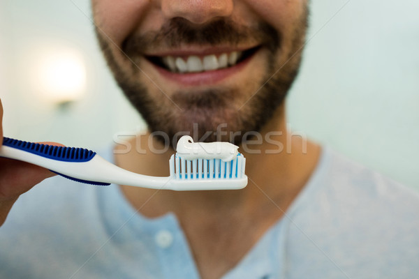 Közelkép boldog fiatalember tart fogkefe fogkrém Stock fotó © wavebreak_media