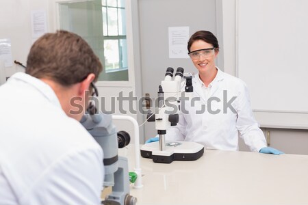Two scientists conducting an experiment looking through a microscope Stock photo © wavebreak_media