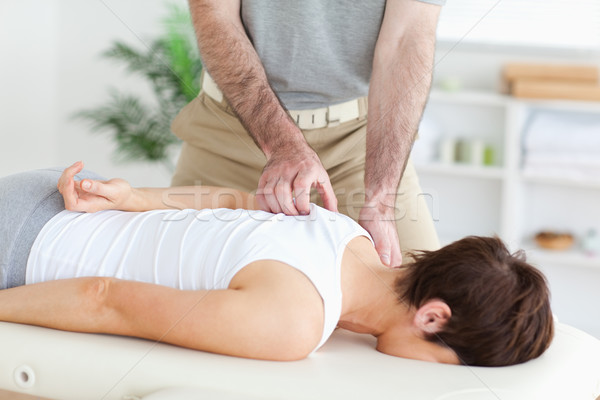 Masseur massaging a brunette woman's shoulder in a room Stock photo © wavebreak_media