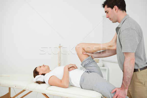 Osteopath stretching the leg of his patient in his medical room Stock photo © wavebreak_media