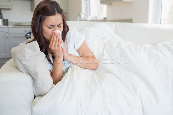 Stock photo: Brunette woman feeling ill on sofa